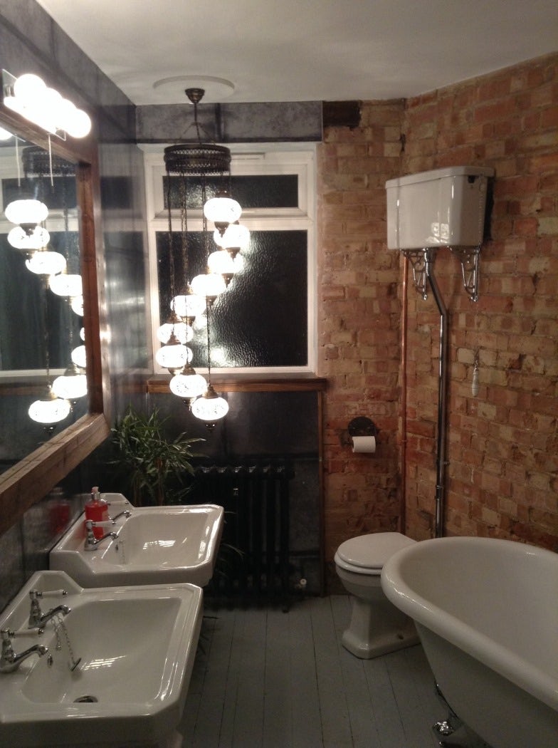 Rough brick walls and exposed metal are gaining popularity in bathrooms