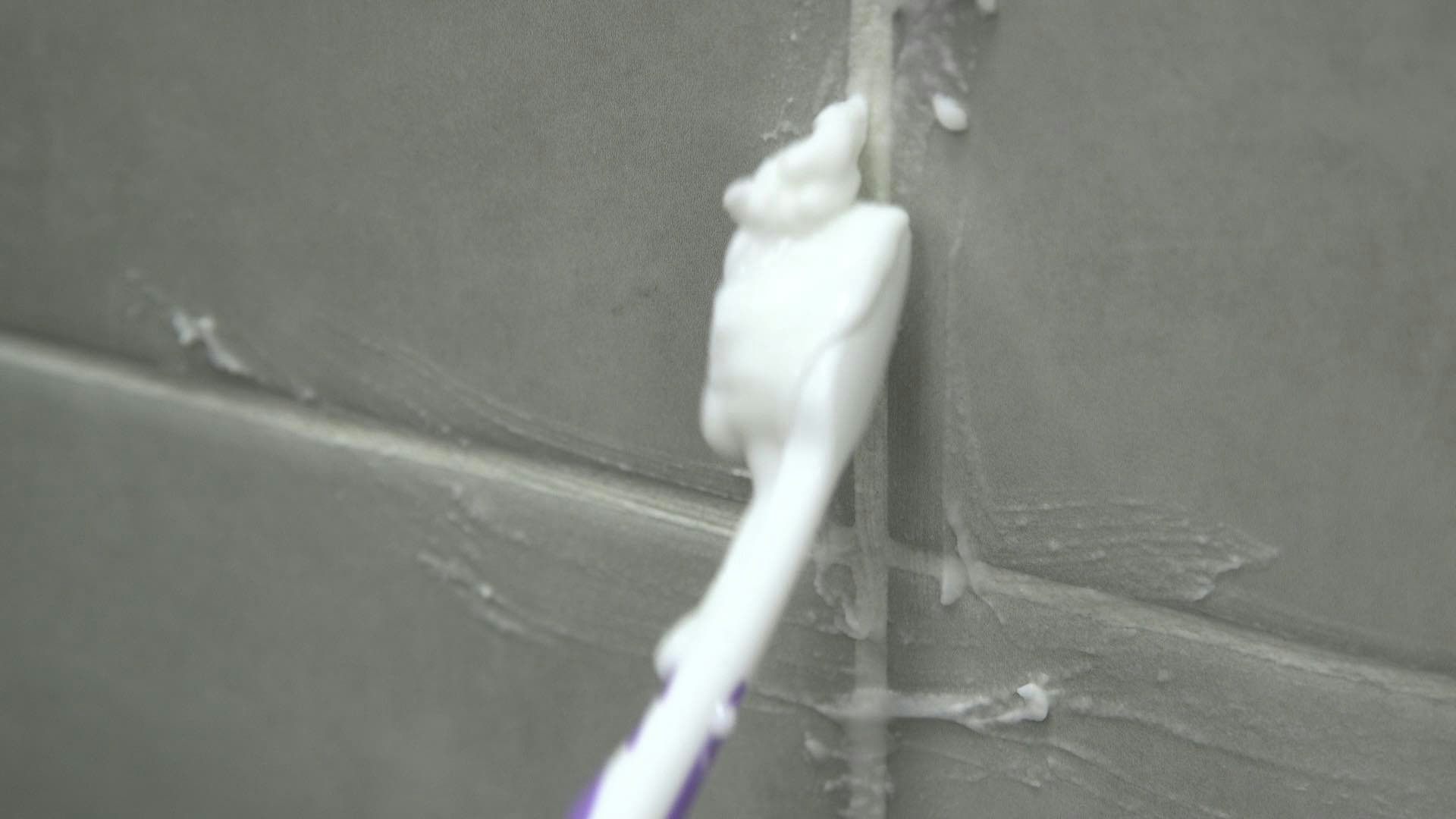 Scrubbing grout lines with a toothbrush